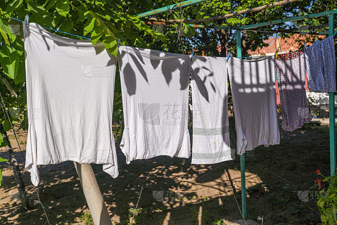 衣服晾在户外，夏天在阳光下晒，在树下部分荫凉