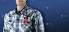 一条红丝带绑在人的胸口，站在彩色墙上，与艾滋病、艾滋病和癌症作斗争