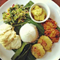 Nasi campur : tempeh curry, corn fritters, potatoes patties, tofu & mushroom pepes and sides of greens on coconut shavings! Warung #semesta #bali #indonesia