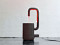 以色列裔巴黎设计师 Arik Levy 最近展示了他设计的 ‘well of life’ 系列 最新灯具产品 Fontana。这个设计的名字来源于其类似于水龙头一样的外形。底座是一个圆筒形容器，侧面设置了一个弯曲的长管，悬在容器上方，而灯具的核心照明装置像水流一样从这个弯曲的管子中流到底座容器里。红色的容器内壁也为这盏灯具提供了有深度的暖色光线。