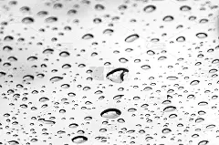 近距离拍摄雨滴落在窗户玻璃上。
