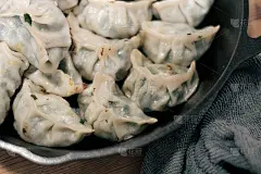 用铸铁煎锅煎自制饺子。