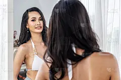 年轻女子看着自己的倒影，检查自己的体型在家里的大镜子