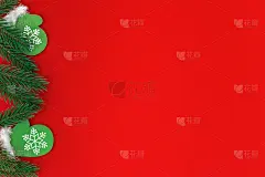 小木制圣诞玩具绿色手套与松树枝在红纸背景与拷贝空间。圣诞贺卡。