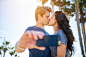 couple kissing for romantic selfie in front of sun and palm trees by Joshua Resnick on 500px