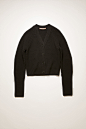  Acne Studios black cardigan is knitted from wool in a chunky ribbed pattern. It's accented with a fully fashioned v-neck, shoulders and rounded sleeves to define the waist. 026