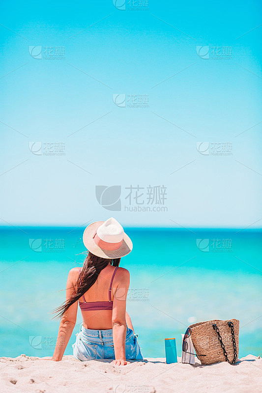 戴着帽子的年轻女子在海滩度假