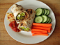 burrito on whole grain california lavash with brown rice, black beans, onion, garlic and low sodium taco seasoning, guacamole, salsa, hummus, olives and romaine lettuce, cucumber and carrots with hummus