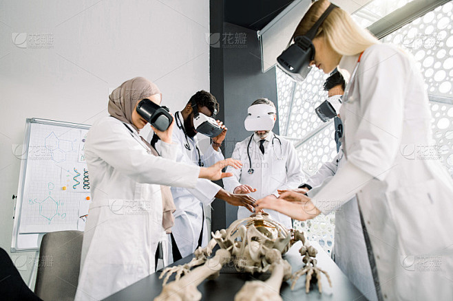 由多民族专业医生、外科医生、骨科医生、戴VR眼镜的学生组成的团队，在现代课堂上与人体骨骼模型一起工作