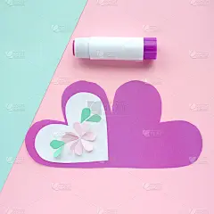 孩子们为母亲节一步一步的纸板工艺品-粉红色的花在紫色的心形状的薄片。剪刀，胶水，纸。孩子们在幼儿园、