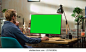 Young Handsome Man Working from Home on Desktop Computer with Green Screen Mock Up Display. Creative Male Checking Social Media, Browsing Internet. Living Room in Bright Loft Apartment.