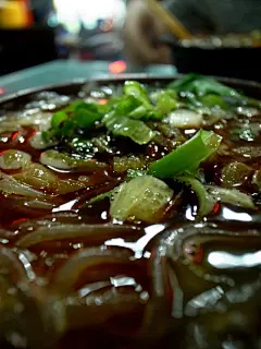 九点钟之后，古城里的食肆大多关门谢客了，到外城区的街边随便找了家粉面店，叫酸辣粉吃。煮粉的大锅就设在店口，上头悬着一颗孤零零的白色灯泡，灯光周围溢出屡屡的雾气。思绪突然就跳到了6、7岁时的元宵节，跟父母逛北宁公园的花灯会，一片红灯笼里有家卖煮汤圆的小店，突兀地悬着那么一枚孤零零的白灯泡。,撒马尔罕往事