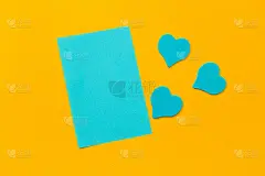蓝色空白纸和粉红色的心在黄色的背景