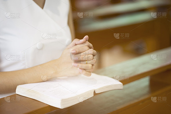 在教堂里，妇女手按圣经祈祷信仰、灵性和基督教。