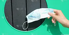 一个男孩的手，他把用过的外科口罩扔进了回收箱