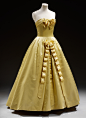 Evening Gown 
Balmain
1956
The vertically looped ribbon decoration and the full, long skirt of this dress were inspired by 18th and 19th century garments.  The dress was worn by Lady Elizabeth von Hofmannsthal and forms part of the Cecil Beaton Collection