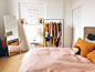 hanging clothes on rack near bed and door