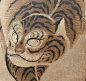 A 17th – 18th century Neko-tora Tiger by Nagasaki school artist Watanabe Shuseki performed with ink and color on paper in yellow bronze silk border with bone rollers. The parchment is aged and gray, giving the sense of a wall painting in some ancient tomb