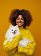 微笑的年轻非洲裔美国女孩抱着小狗的工作室肖像图片素材