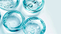 Top view of light blue liquid gel bubbles in glassware on a white background, cosmetic product photography, macro shot with focus stacking, detailed and high resolution, advertising stock photo, commercial photography, close up, studio lighting, minimalis