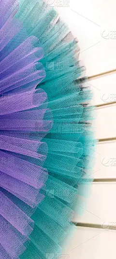 碎片对彩色芭蕾舞短裙。摘要特写选择性聚焦紫色和蓝绿色网格对角线。小针脚织物的褶皱、卷曲。垂直横幅，墙