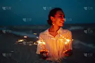 手上闪闪发光。女人与圣诞烟花在自然和黄昏天空背景。