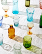 Colored Glassware with Long Colorful Shadows on White Linen