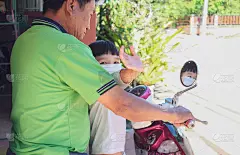 爷爷带孙子赶集，戴上白色口罩保护新冠肺炎