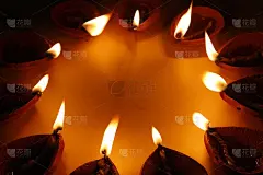 美丽的股票照片的传统橙色棕色赤陶土粘土diya灯燃烧在一个圆圈形成，黑暗和黄色的背景，文本复制空间。