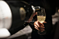 Waiter pouring champagne into the wine glass in restaurant. Blurry background