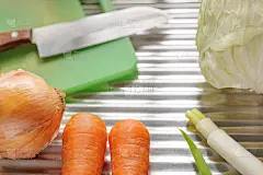 不锈钢背景上的炊具和蔬菜