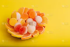 微距照片的多色果酱果冻糖果。用柠檬和橙子片做成的橘子酱甜点。果冻糖果的甜度是黄色和橙色的。
