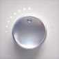 This may contain: a round metal object on a white surface with small lights around it and the top half visible