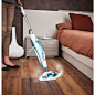 a woman is using a steam mop to clean the wood floor in her bedroom