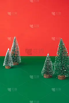 圣诞树装饰装饰在绿色的桌子上，背景是鲜艳的红色。节日庆祝贺卡的副本空间