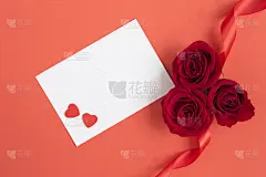 顶视图的空白白纸为文本，红色背景上的红玫瑰和心。副本的空间。特写镜头。