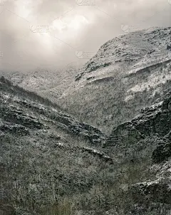 壮丽的雪山前有岩石峭壁和森林