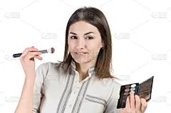 小女孩涂着腮帮子。女孩做化妆