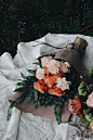 Large bouquets of pink carnations wrapped in paper and laid down on the ground