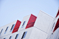 A white residential building facade with red balconies in Los Angeles