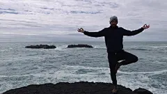 在多岩石的海岸上沉思的人