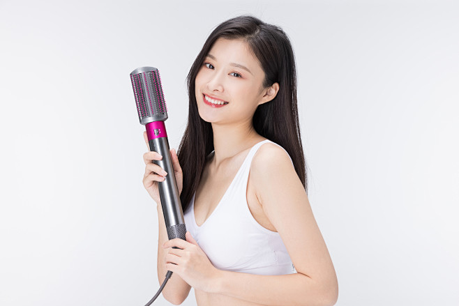 摄图网_501713376_使用卷发棒卷...