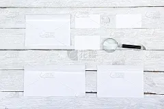 的名片。公司文具设置模型。木桌上的空白纹理品牌ID元素。放大镜。俯视图