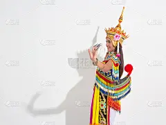 年轻女子身穿泰国传统南方服装，头戴头饰，表演基本图案的民间舞蹈，黑色的影子反射在白色的背景