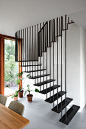 Modern black stairs that contrast the white walls and wood accents.