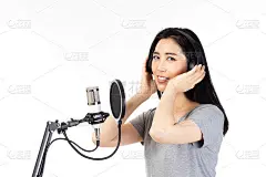 年轻的亚洲女子与麦克风录音歌曲在音乐工作室快乐的表情脸孤立在白色的背景。