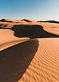 brown sand dunes under blue sky during daytime