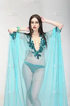 美丽的年轻女子穿着蓝色透明的时装