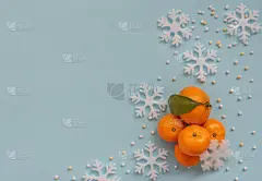 圣诞节蓝色的背景与橙色的橘子和白色的雪花。新年贺卡。平的风格。