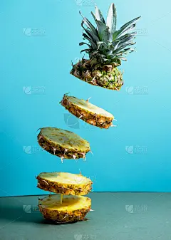 一个美丽的新鲜美味的菠萝飞在蓝色对比明亮的背景。前视图。水平的。副本的空间。概念。